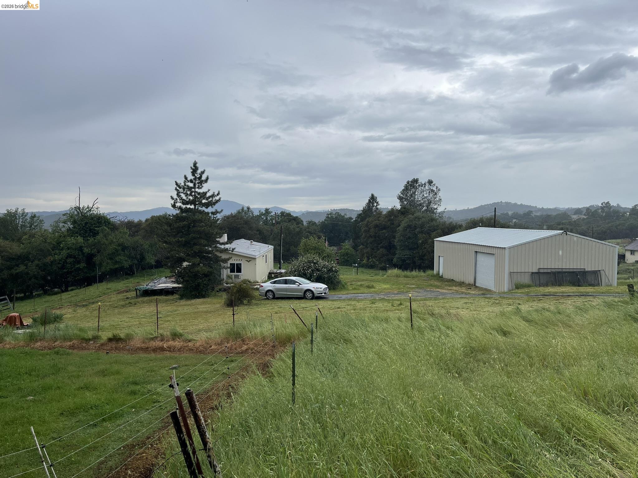 19644 Rawhide Road Sonora, CA 95370 - Photo 3 of 45 View of yard with a view of countryside, an outbuilding, a detached garage, and a pole building