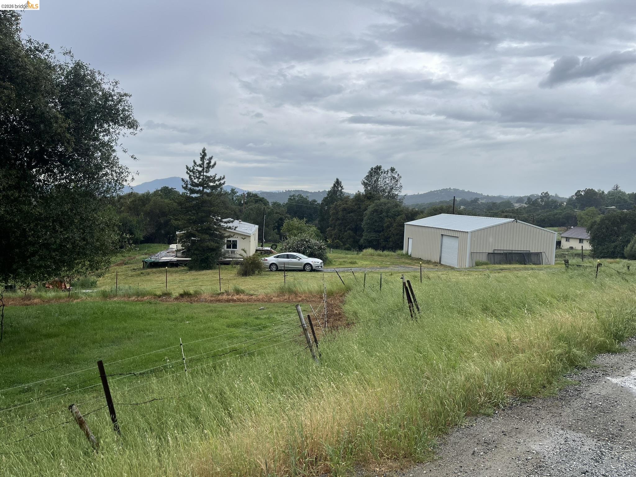 19644 Rawhide Road Sonora, CA 95370 - Photo 4 of 45 View of yard with a view of rural / pastoral area, an outdoor structure, a garage, an outbuilding, and driveway