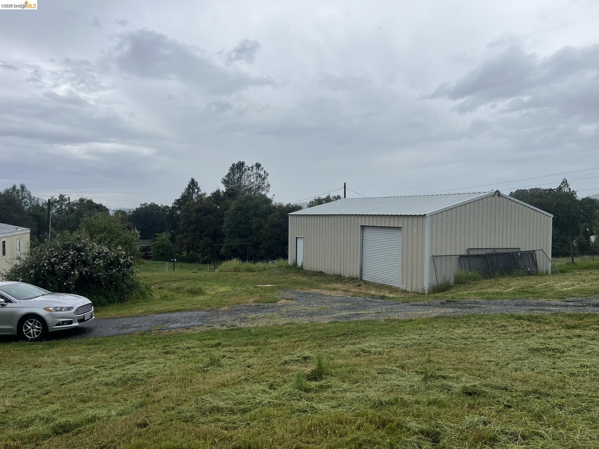 19644 Rawhide Road Sonora, CA 95370 - Photo 7 of 45 View of grassy yard featuring an outbuilding, a garage, and a pole building