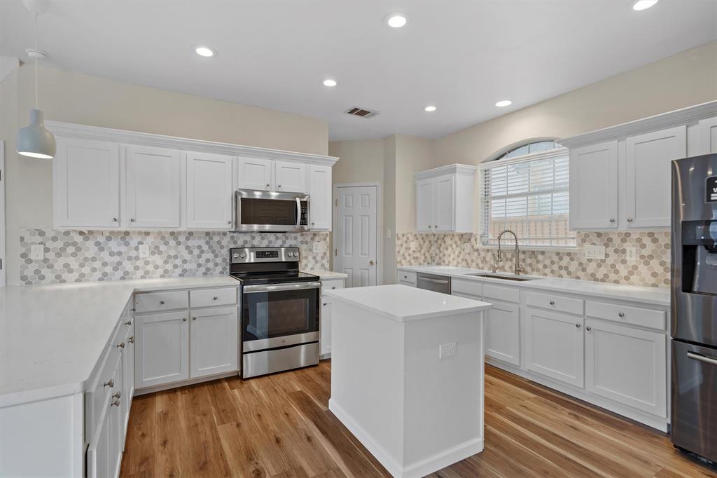 1719 Live Oak Lane Allen, TX 75002 - Photo 16 of 38 a kitchen with granite countertop white cabinets and stainless steel appliances