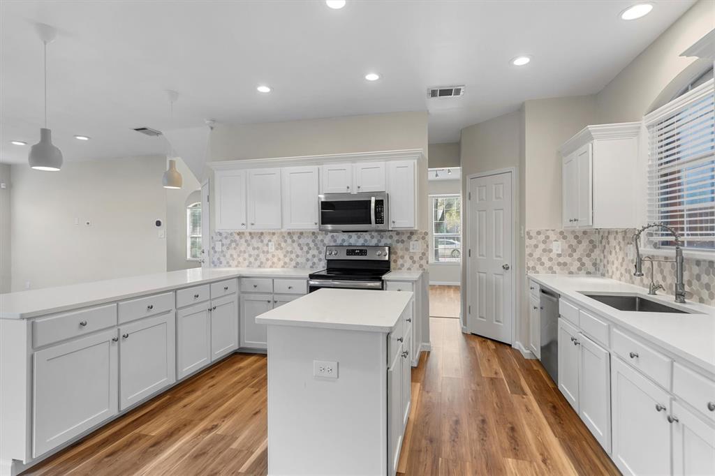 1719 Live Oak Lane Allen, TX 75002 - Photo 17 of 38 a large kitchen with cabinets stainless steel appliances a sink and a stove