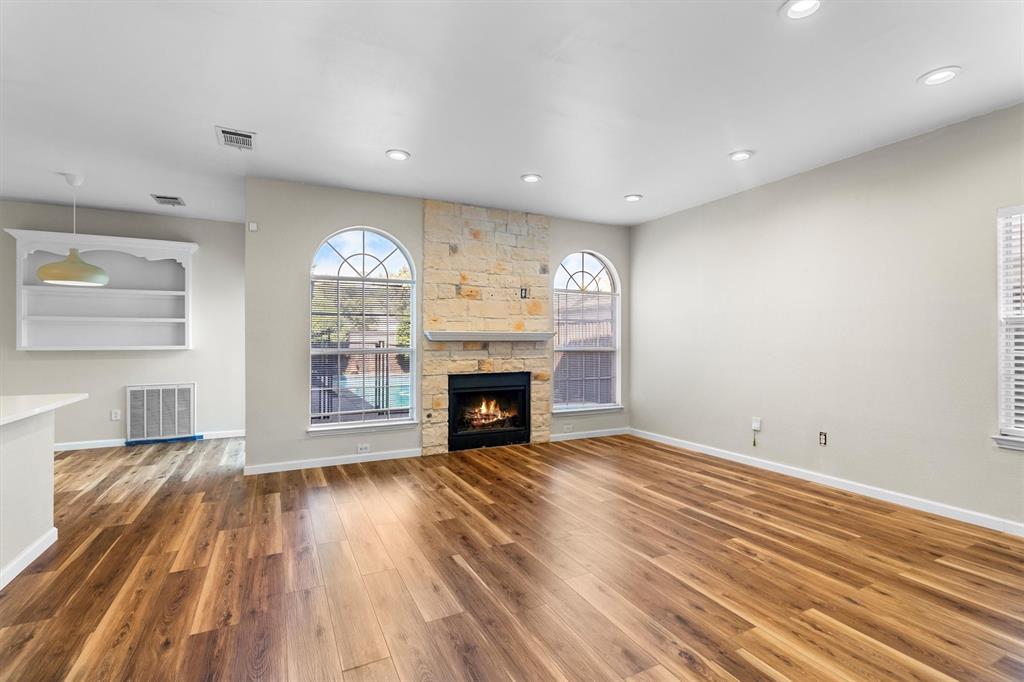 1719 Live Oak Lane Allen, TX 75002 - Photo 10 of 38 an empty room with wooden floor fireplace and windows