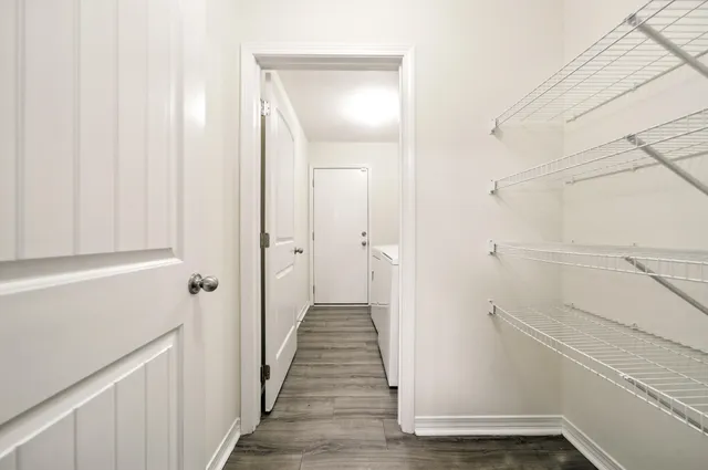 a view of a hallway with wooden floor and staircase