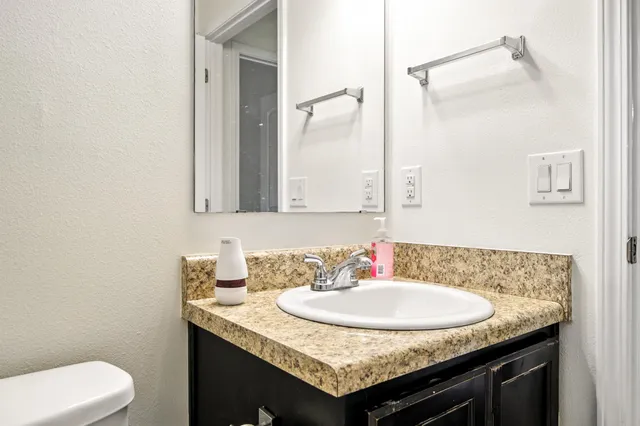 a bathroom with a granite countertop sink and a mirror