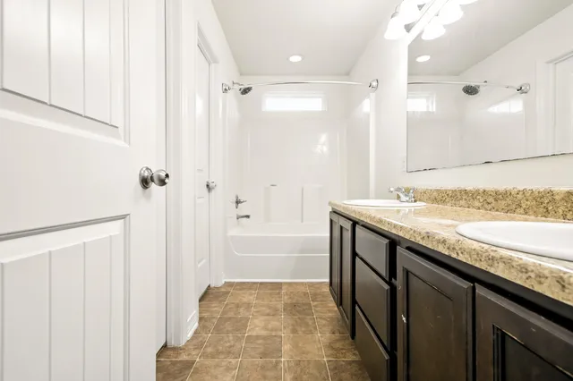 a bathroom with a granite countertop sink a toilet and shower