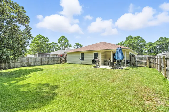 a front view of house with yard barbeque and outdoor seating