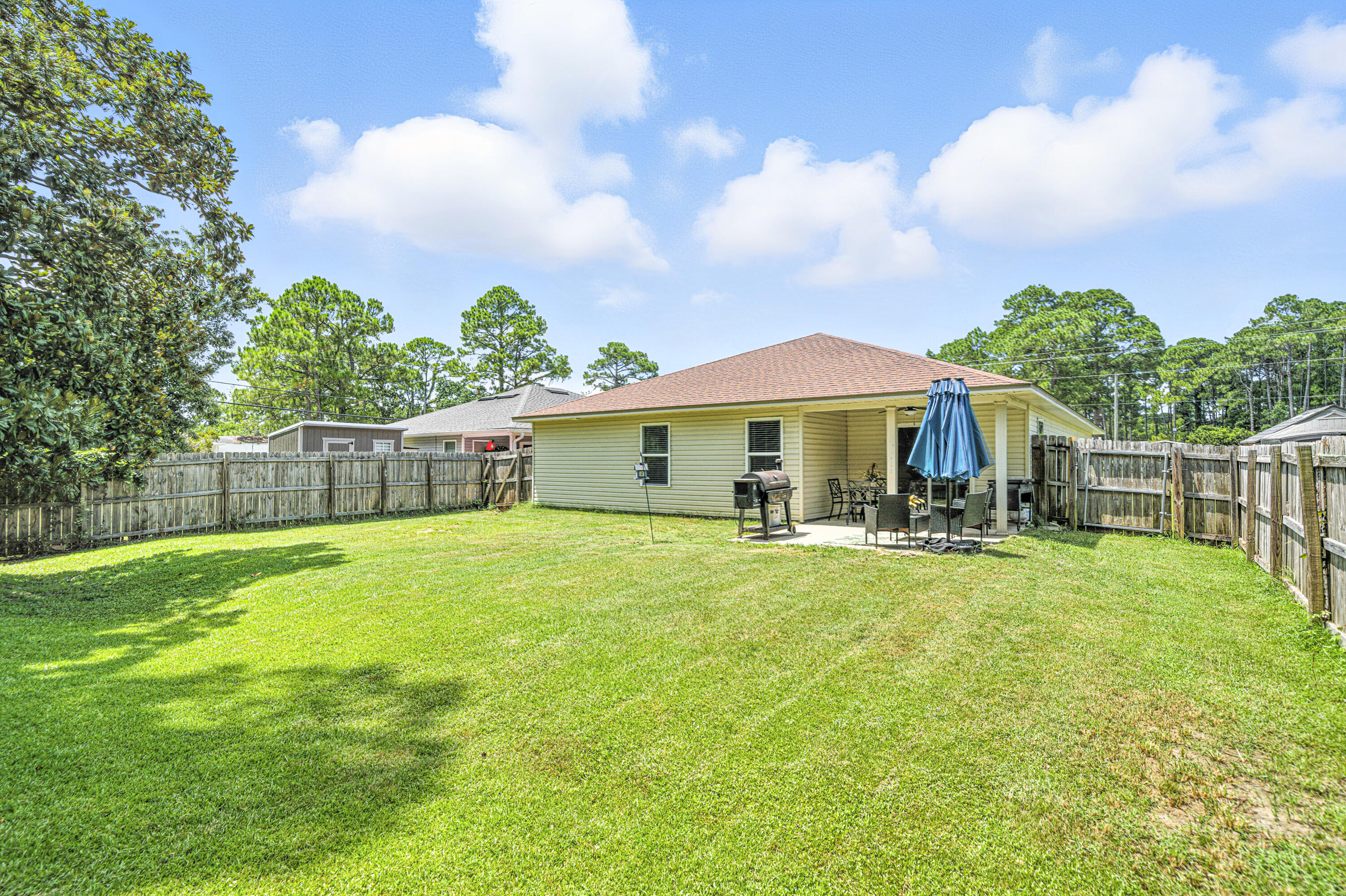 9207 Timber Lane Navarre, FL 32566 - Photo 23 of 24 a front view of house with yard barbeque and outdoor seating
