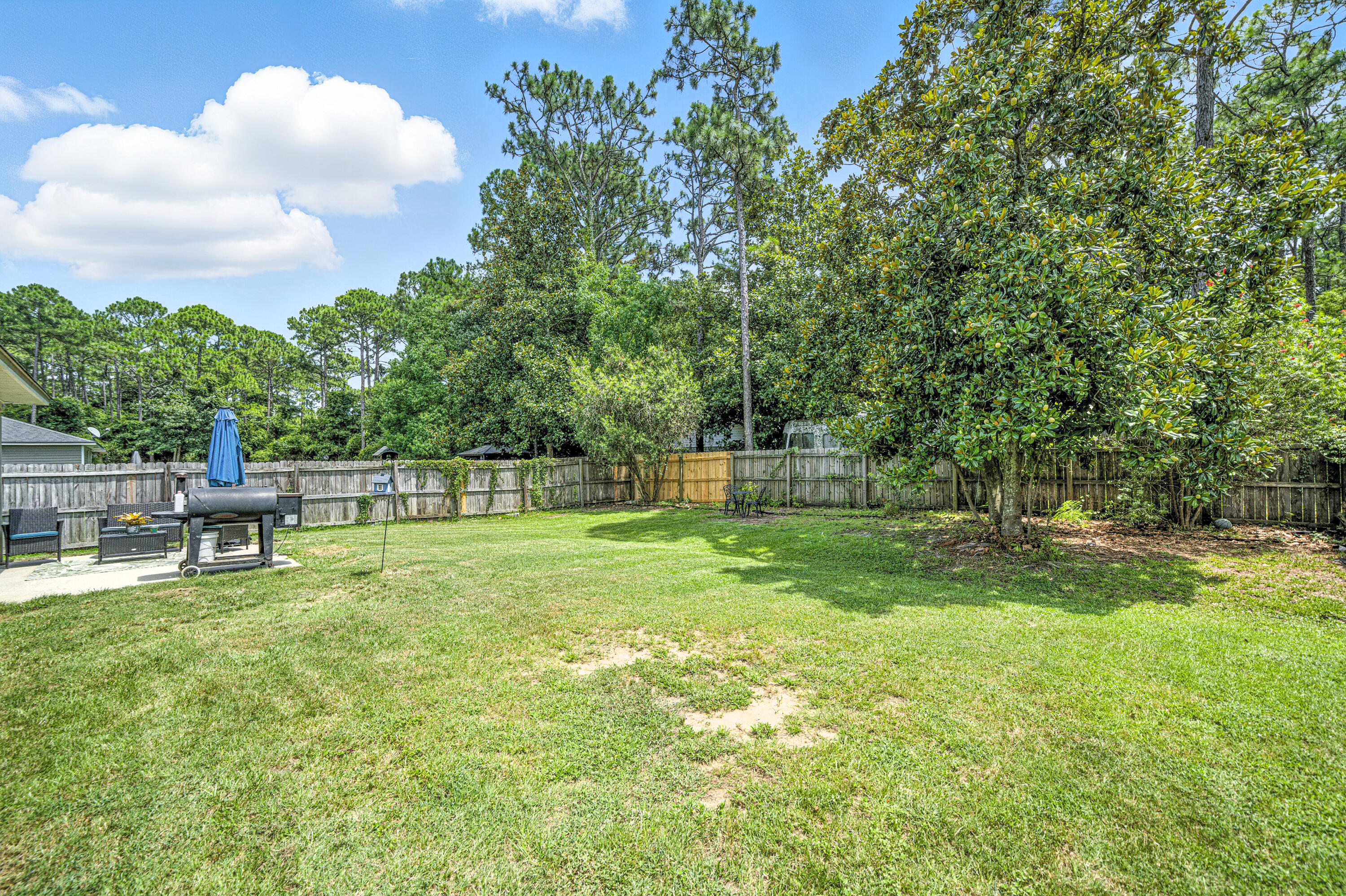 9207 Timber Lane Navarre, FL 32566 - Photo 24 of 24 a backyard of a house with table and chairs