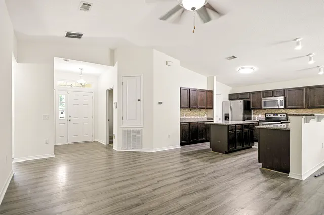 a view of kitchen with refrigerator microwave and stove top oven