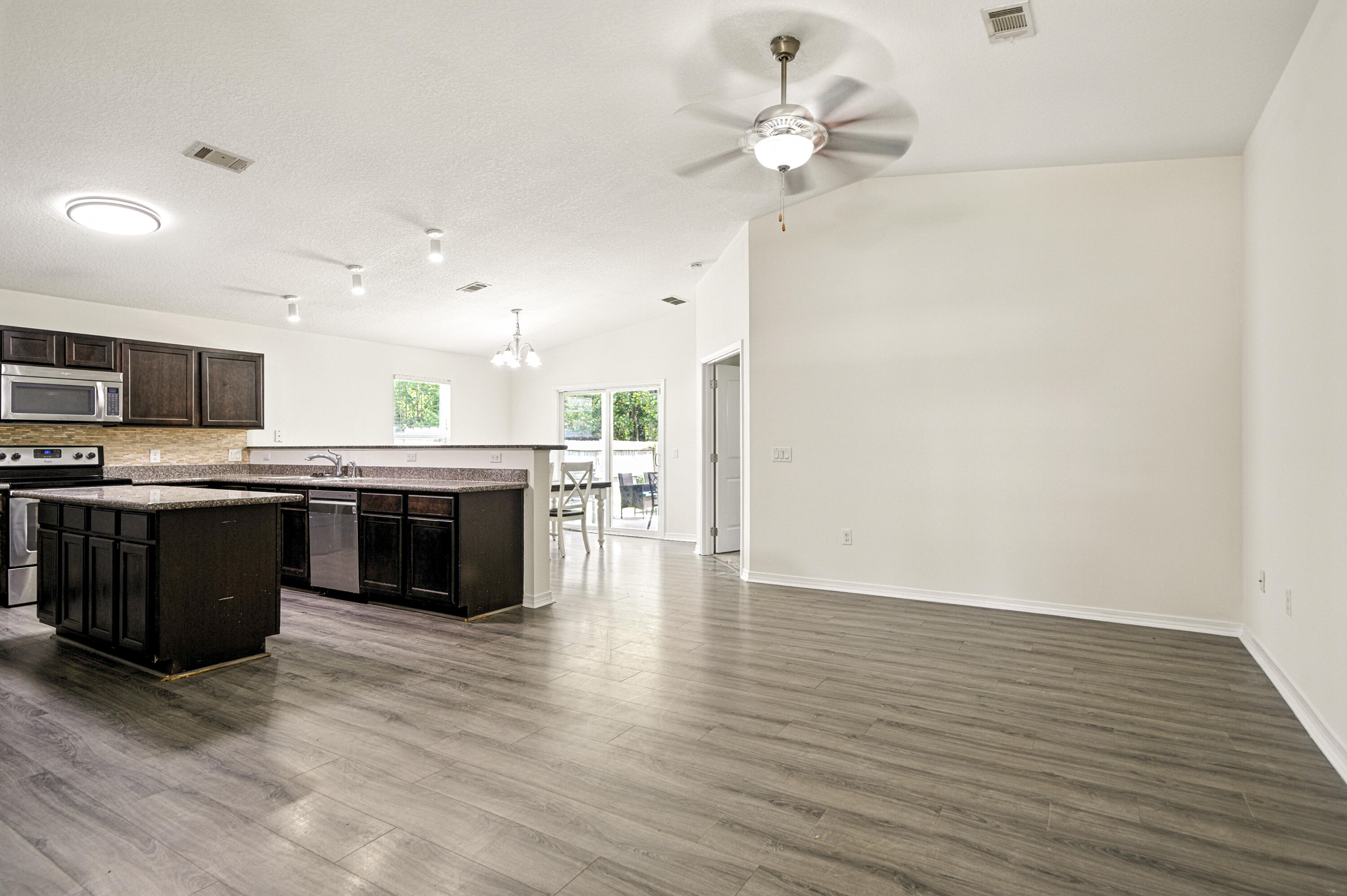 9207 Timber Lane Navarre, FL 32566 - Photo 4 of 24 a large kitchen with stainless steel appliances granite countertop a stove cabinets and wooden floor