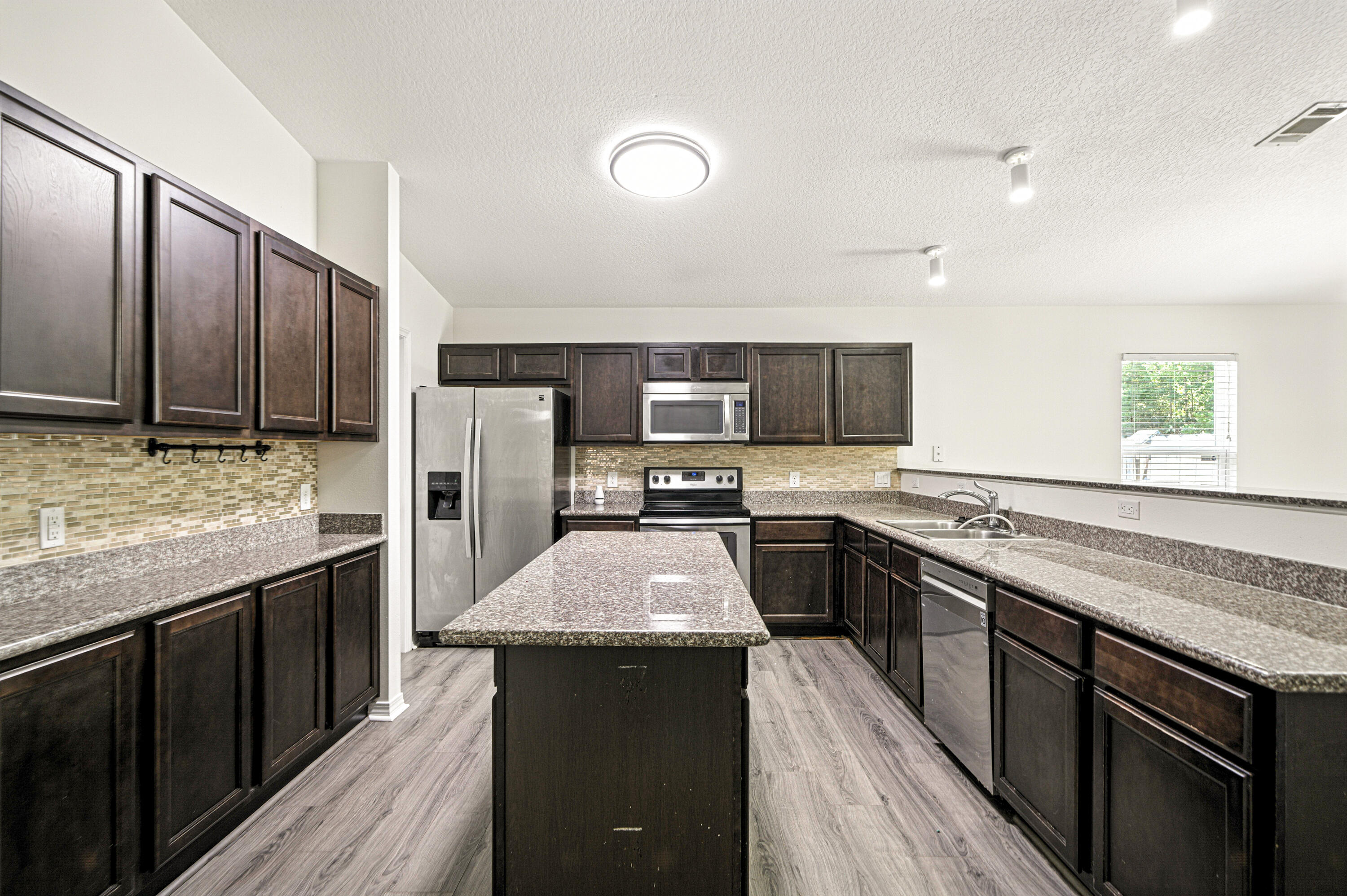 9207 Timber Lane Navarre, FL 32566 - Photo 5 of 24 a kitchen with stainless steel appliances granite countertop refrigerator stove microwave and sink