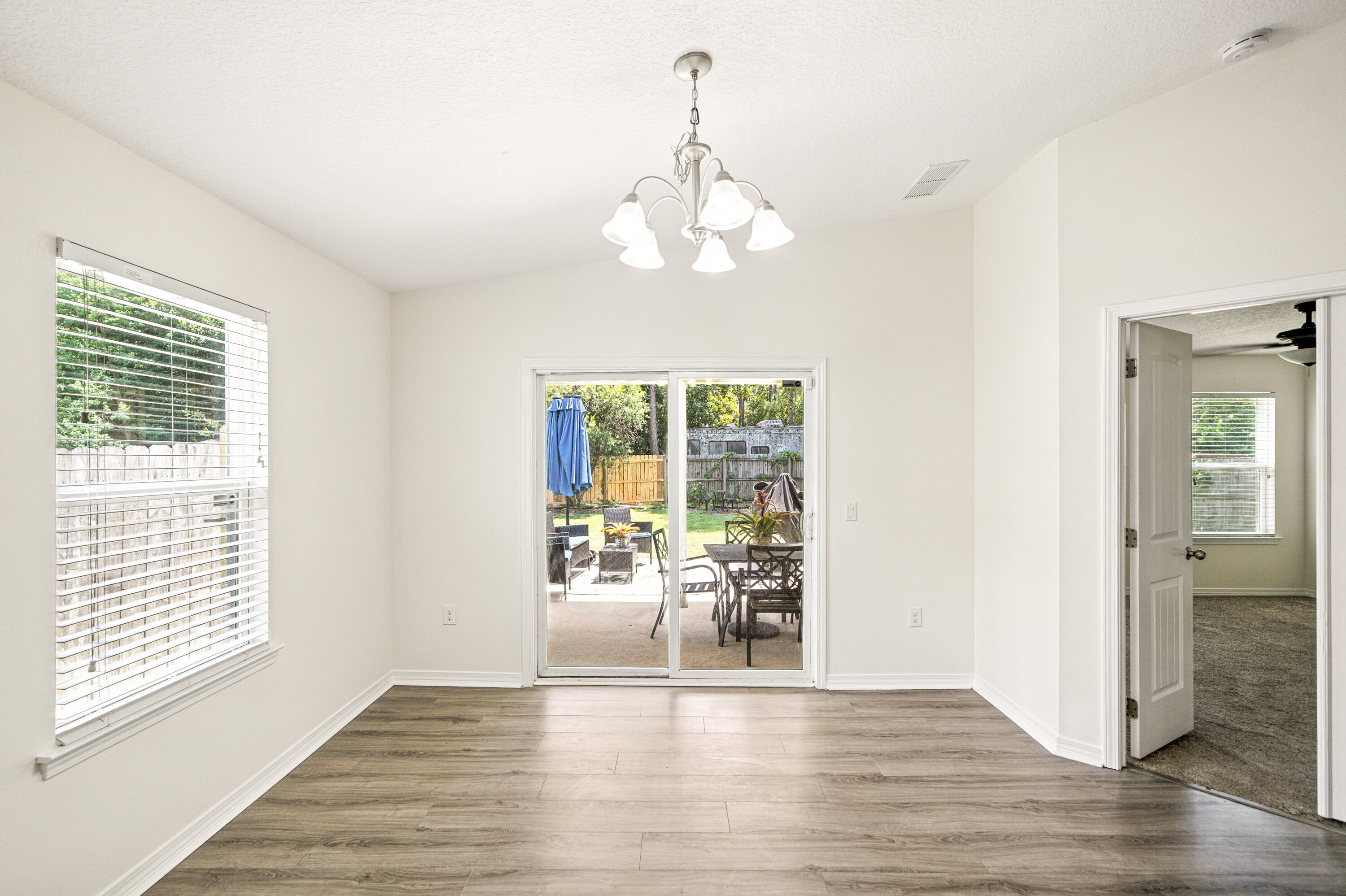 9207 Timber Lane Navarre, FL 32566 - Photo 7 of 24 a view of an empty room with wooden floor and a window