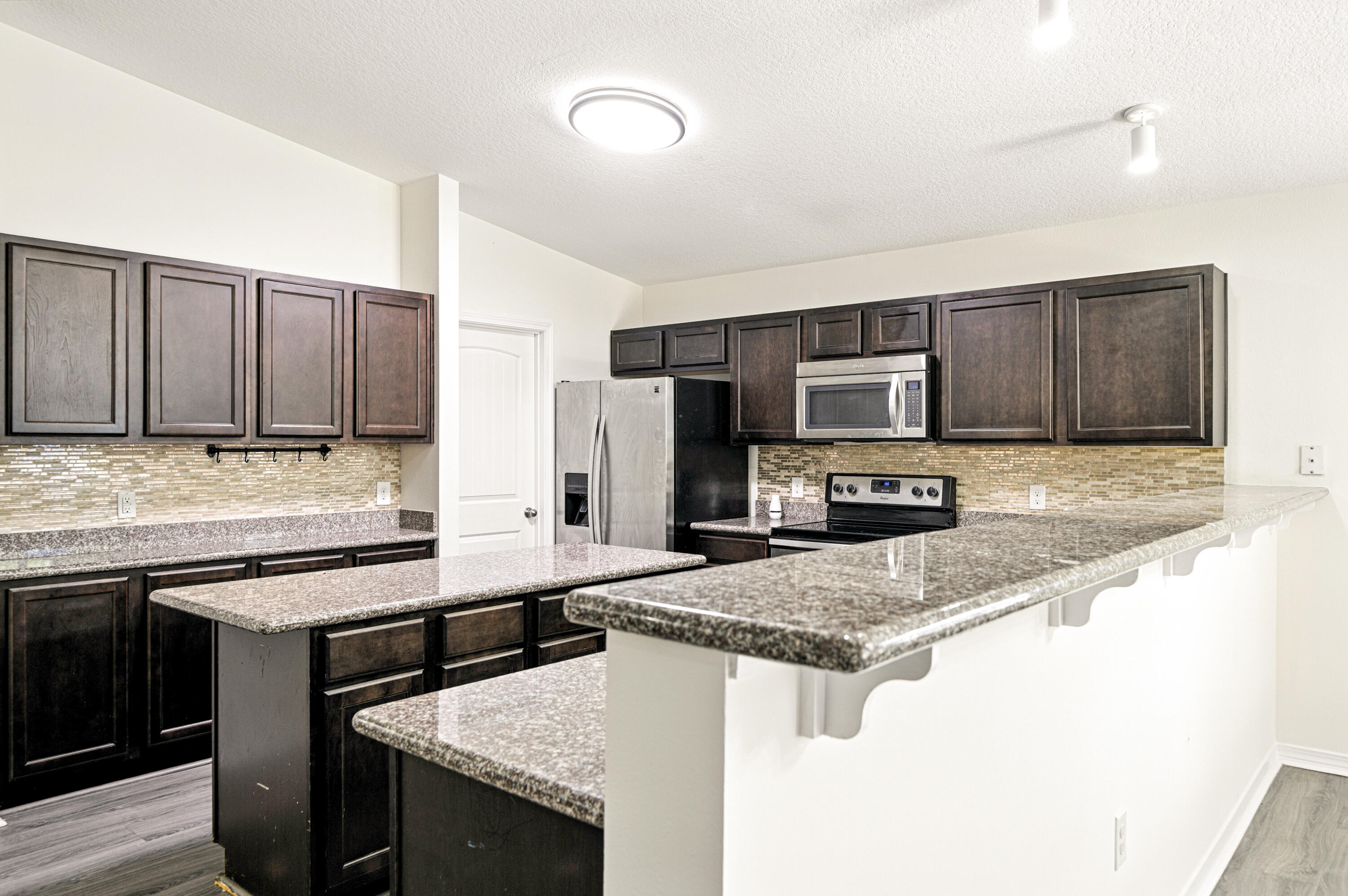 9207 Timber Lane Navarre, FL 32566 - Photo 8 of 24 a kitchen with stainless steel appliances granite countertop a sink stove microwave and refrigerator