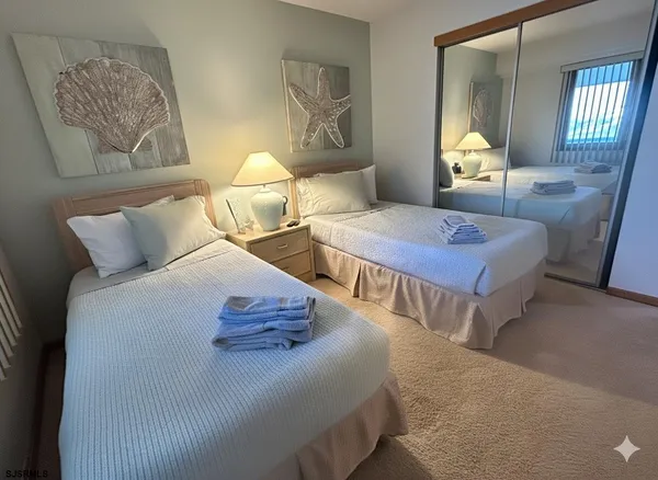 a bedroom with two beds and painting on the wall