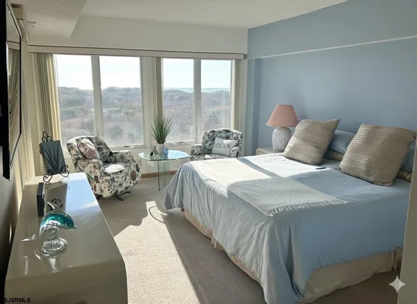 a bed sitting in a bedroom next to a large window with couch