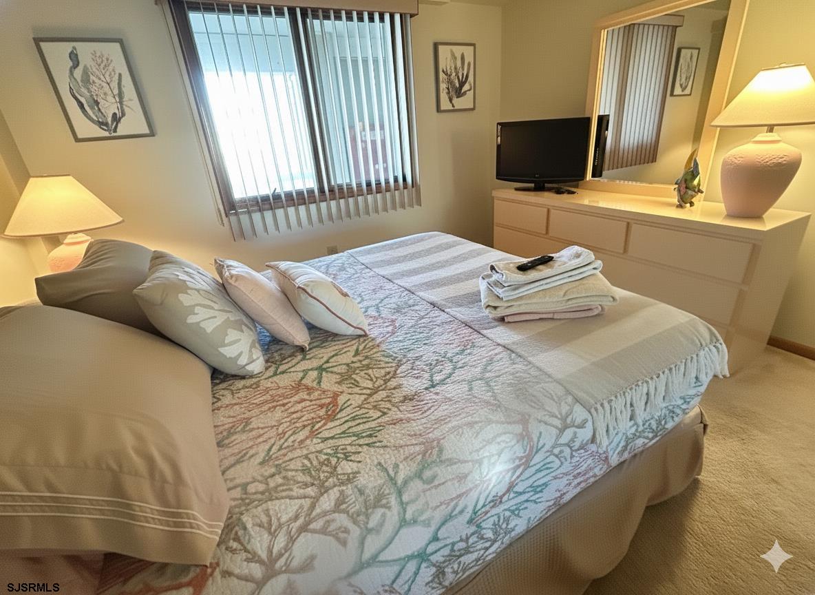 400 West Brigantine Avenue, Unit 2 Brigantine, NJ 08203 - Photo 7 of 24 a bedroom with a bed and flat screen tv