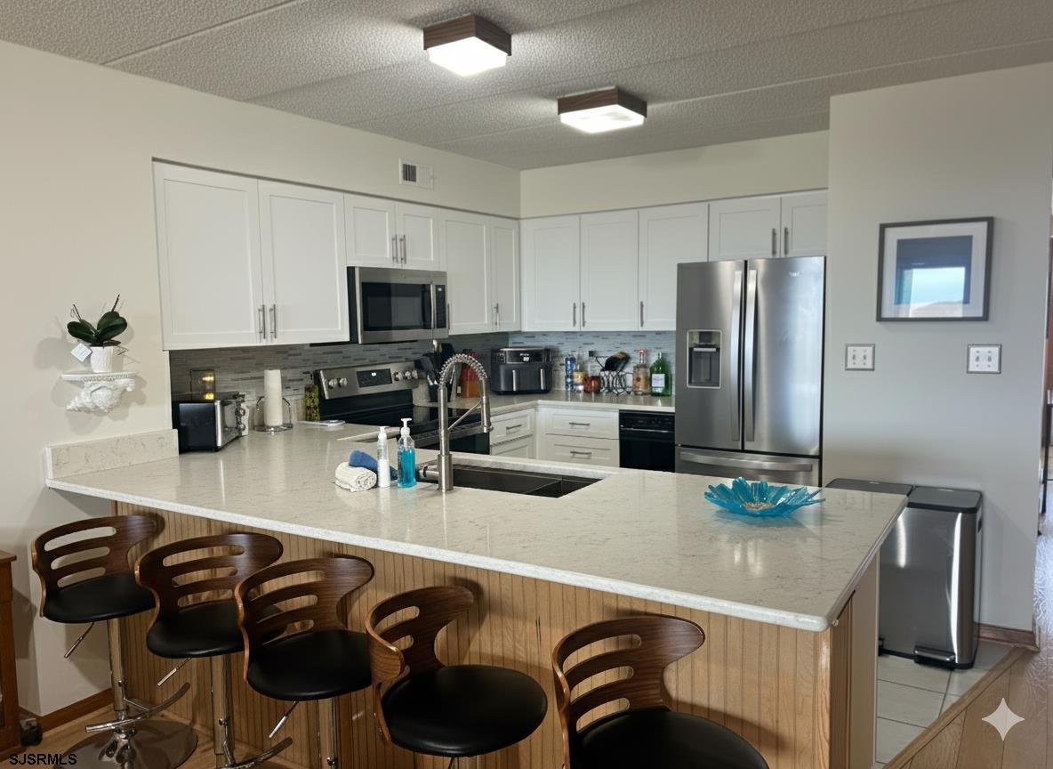 400 West Brigantine Avenue, Unit 2 Brigantine, NJ 08203 - Photo 10 of 24 a kitchen with kitchen island a refrigerator stove and microwave