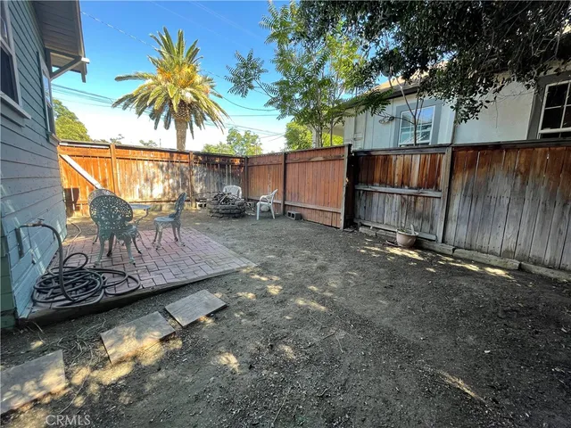 a view of a backyard with a large tree and wooden fence
