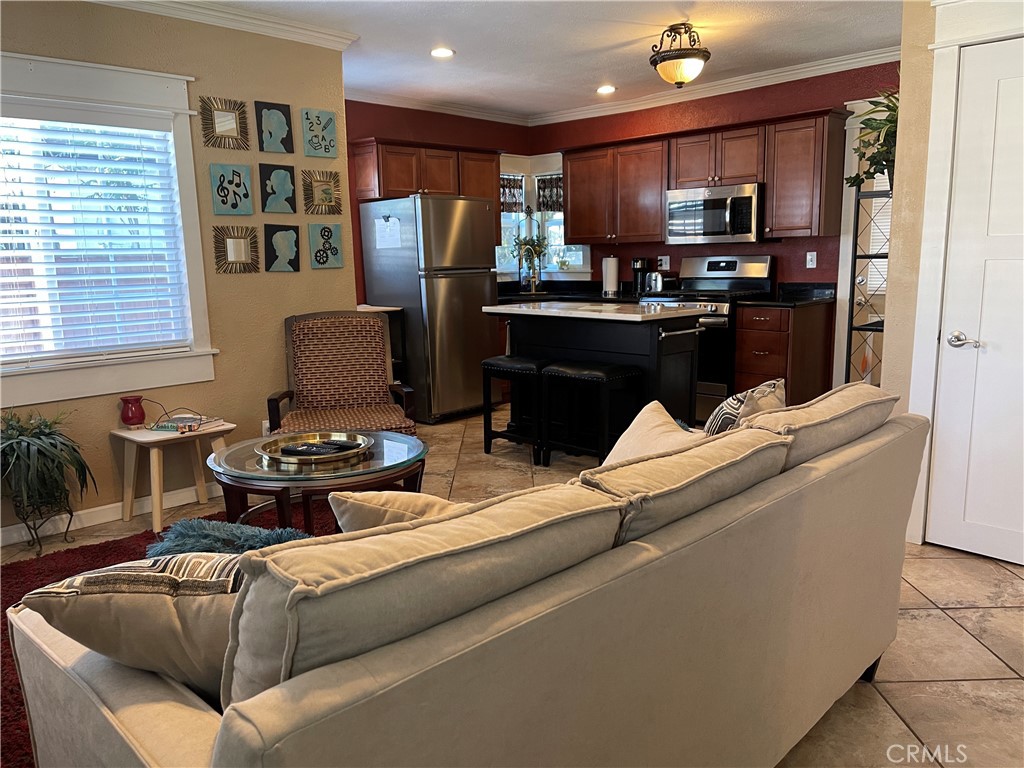 113 East 11th Street Redlands, CA 92374 - Photo 4 of 18 a living room with stainless steel appliances kitchen island granite countertop a refrigerator a sink dishwasher a stove and a microwave oven on the blue kitchen countertops with a dining table