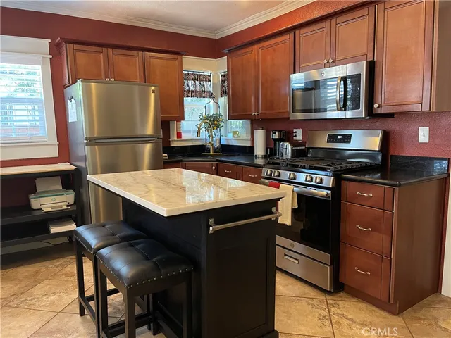 a kitchen with a refrigerator a microwave a sink and cabinets