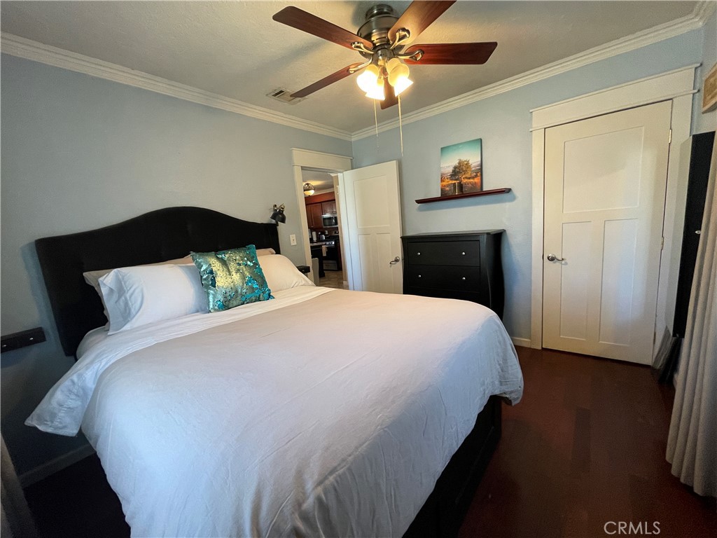 113 East 11th Street Redlands, CA 92374 - Photo 9 of 18 a bedroom with a bed and a chandelier