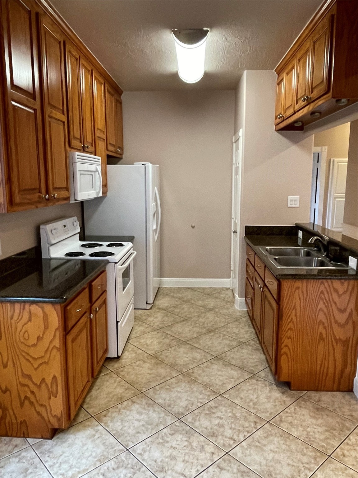 1018 South Booth Lane Alvin, TX 77511 - Photo 7 of 19 a kitchen with stainless steel appliances granite countertop a stove a sink and a refrigerator