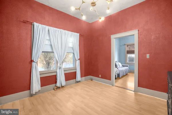 a view of a hallway with wooden floor and cabinet