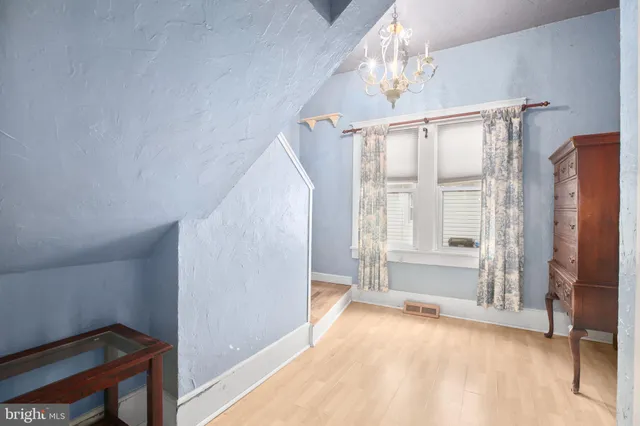 a view of a dining room with furniture a chandelier and wooden floor
