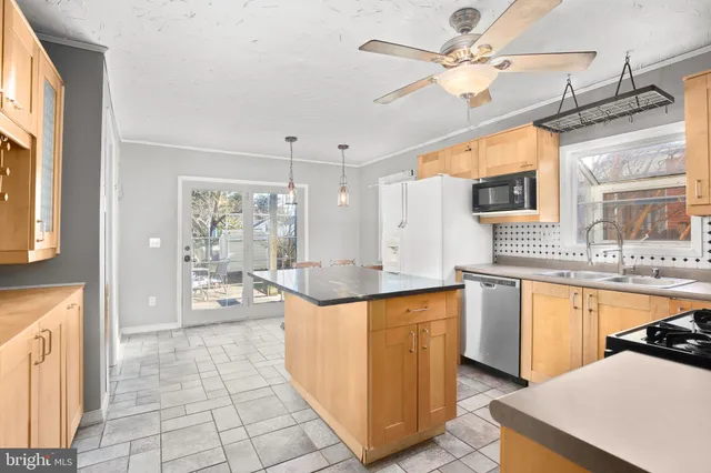 a kitchen with stainless steel appliances granite countertop a sink and a refrigerator