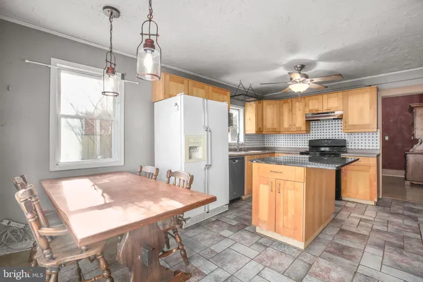 a kitchen with stainless steel appliances granite countertop a stove a sink a refrigerator and island