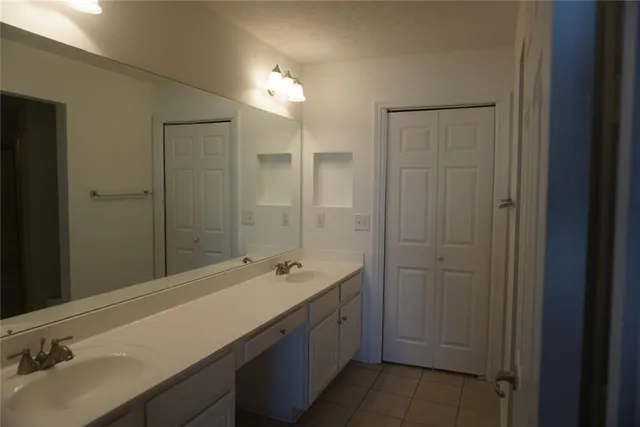 a bathroom with a granite countertop toilet and a sink