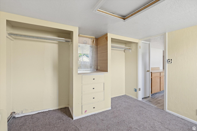 395 North 400 West Logan, UT 84321 - Photo 30 of 48 Room featuring carpet flooring, built-in open closets with hanging rods, built-in dresser with drawers, and a window