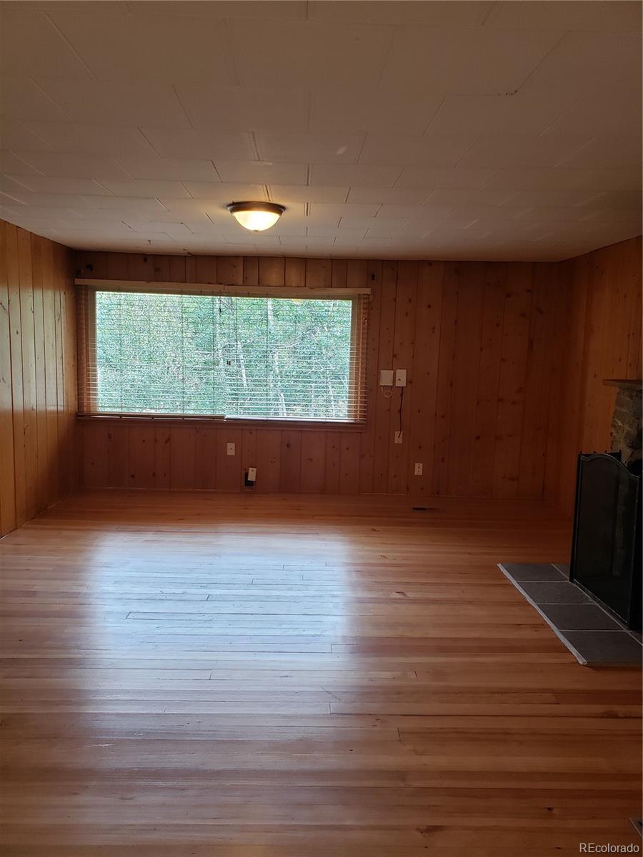 11769 Ranch Elsie Road Golden, CO 80403 - Photo 13 of 39 an empty room with wooden floor and windows