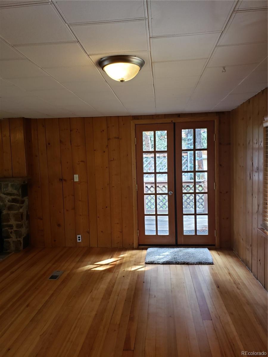 11769 Ranch Elsie Road Golden, CO 80403 - Photo 14 of 39 an empty room with wooden floor and windows