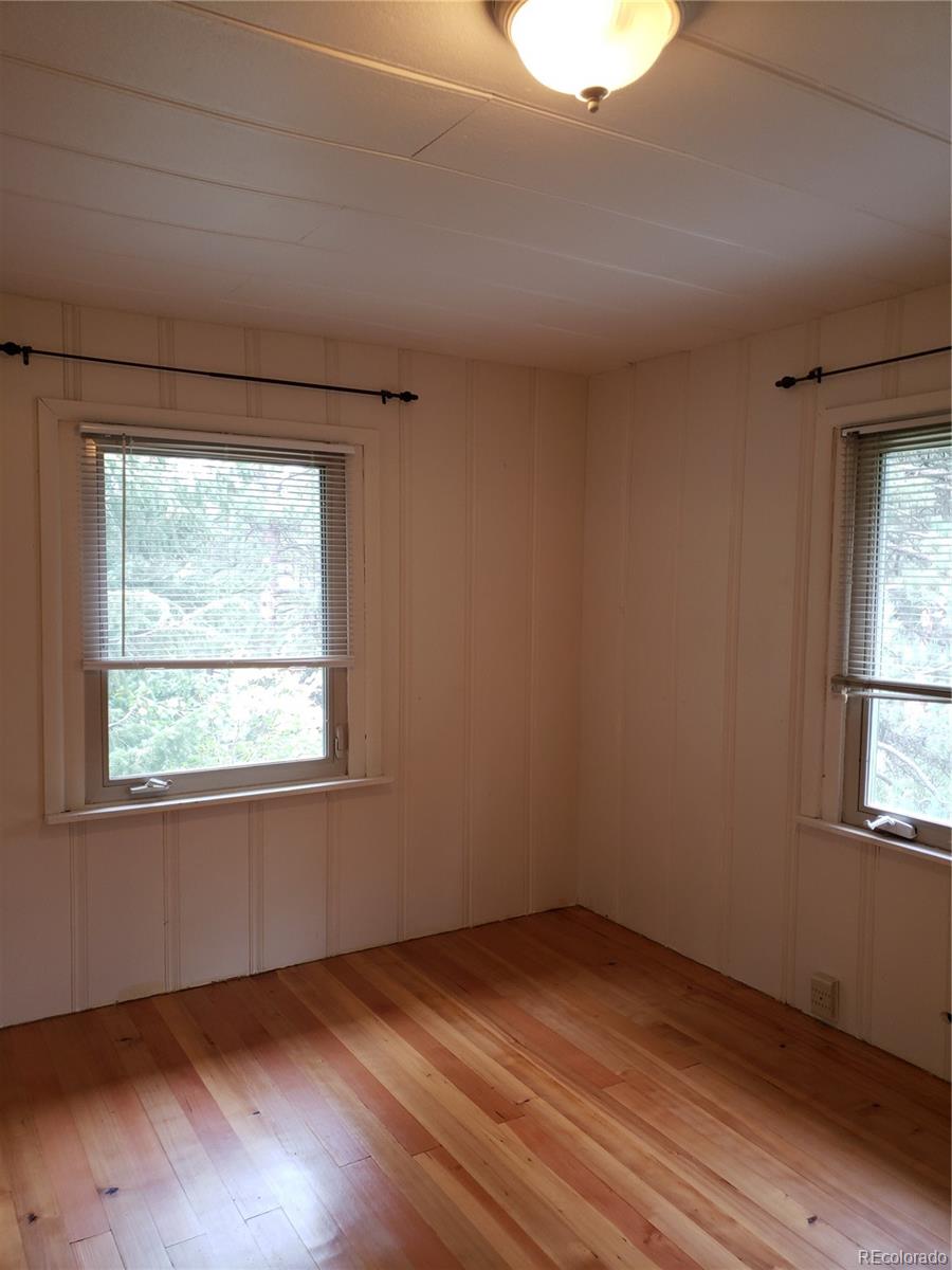11769 Ranch Elsie Road Golden, CO 80403 - Photo 19 of 39 an empty room with wooden floor and windows