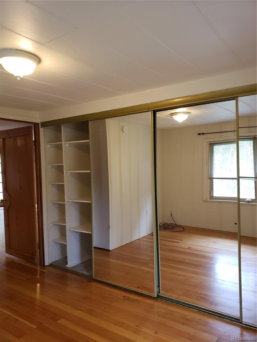 11769 Ranch Elsie Road Golden, CO 80403 - Photo 20 of 39 a view of an empty room with wooden floor and a window