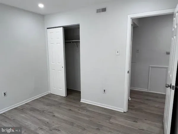an empty room with wooden floor and closet