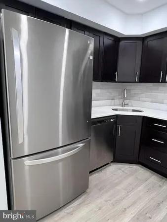 a kitchen with stainless steel appliances granite countertop a refrigerator a sink and a stove