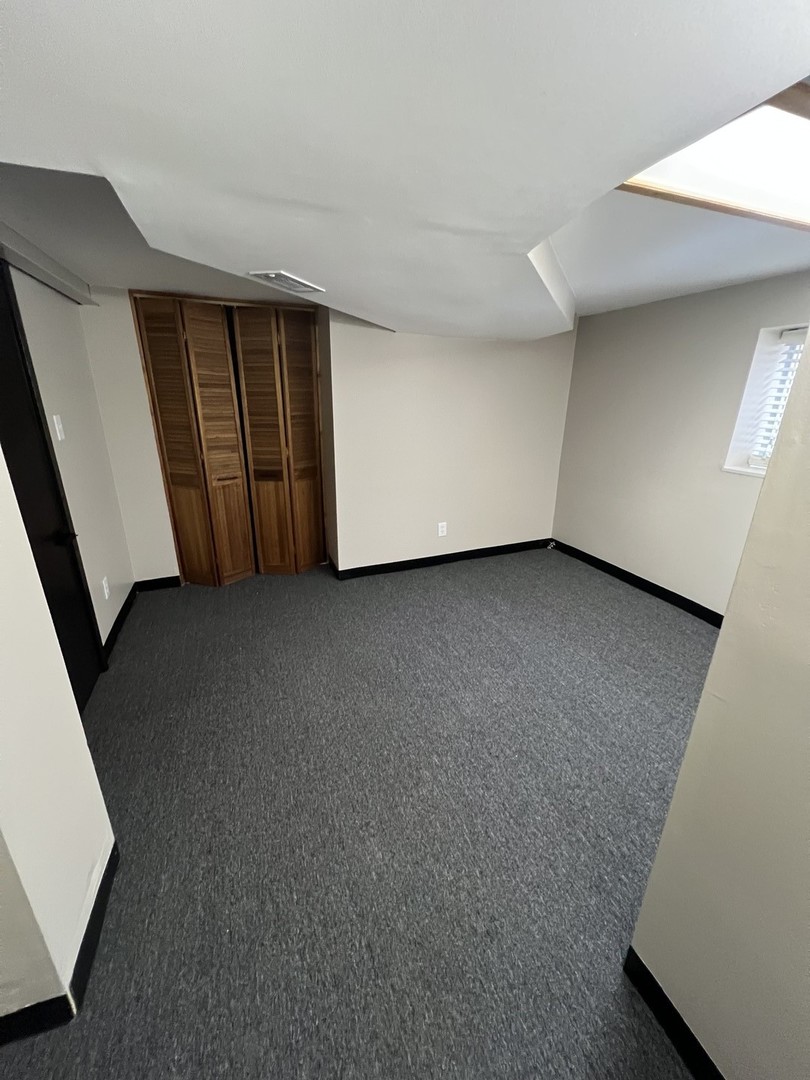 4818 North Moody Avenue, Unit G Chicago, IL 60630 - Photo 10 of 11 a view of an empty room with a window