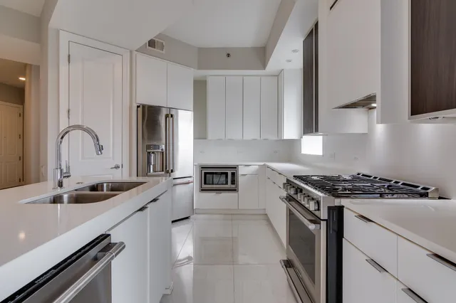 a kitchen with stainless steel appliances granite countertop a sink and a stove