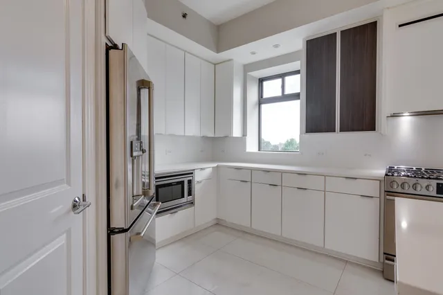 a kitchen with granite countertop a sink stainless steel appliances and cabinets