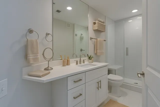 a bathroom with a double vanity sink toilet and shower