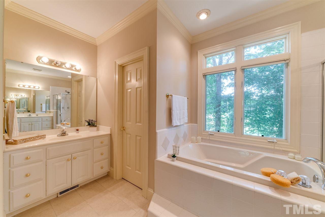 8912 Carnoustie Way Raleigh, NC 27613 - Photo 13 of 25 a spacious bathroom with a tub sink double vanity and mirror