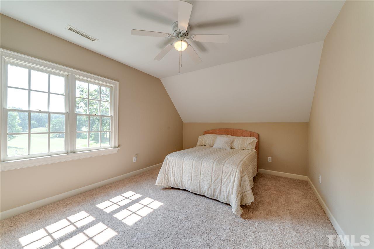 8912 Carnoustie Way Raleigh, NC 27613 - Photo 14 of 25 a bedroom with a bed and a large window