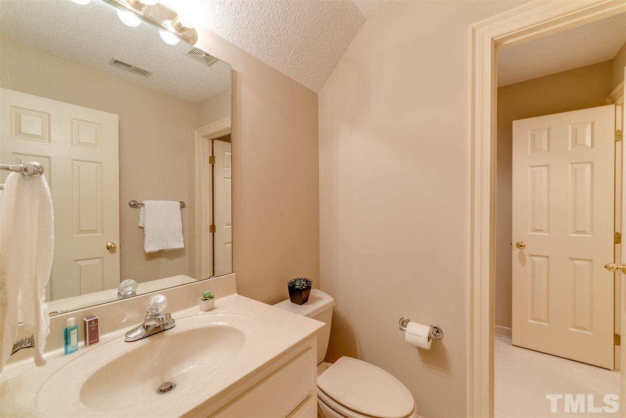 8912 Carnoustie Way Raleigh, NC 27613 - Photo 17 of 25 a bathroom with a sink vanity mirror and toilet