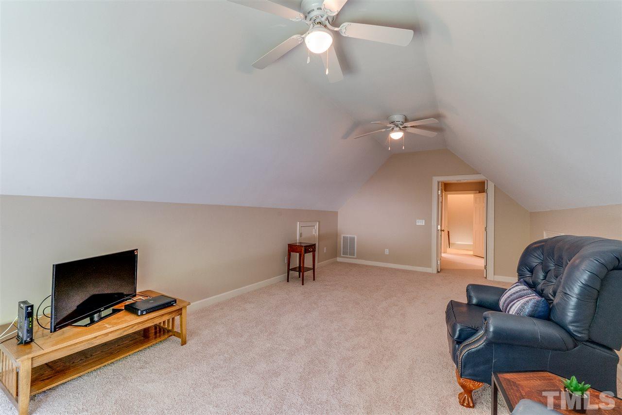 8912 Carnoustie Way Raleigh, NC 27613 - Photo 19 of 25 a living room with furniture and a ceiling fan