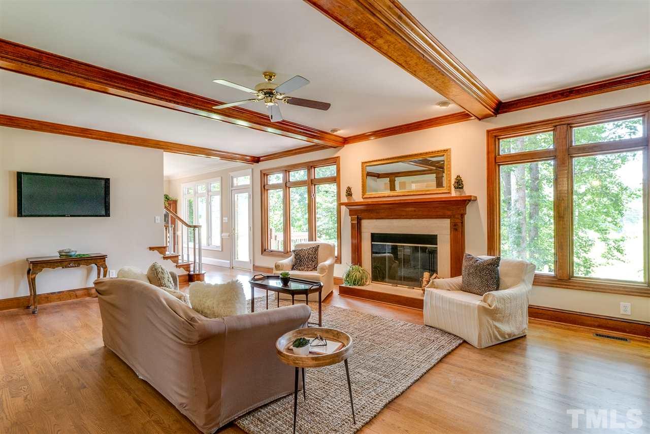 8912 Carnoustie Way Raleigh, NC 27613 - Photo 6 of 25 a living room with furniture a fireplace and a flat screen tv