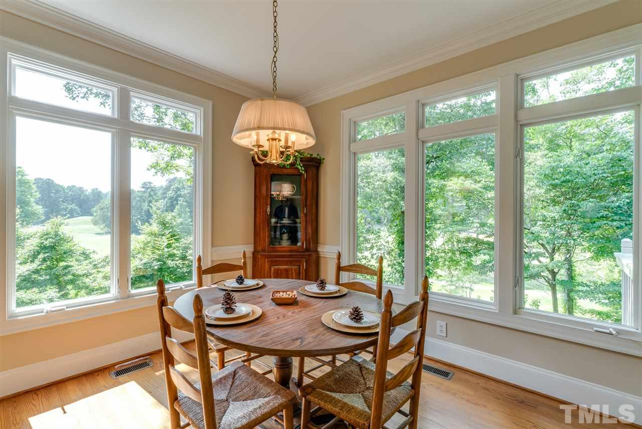 8912 Carnoustie Way Raleigh, NC 27613 - Photo 7 of 25 a view of a dining room with furniture large windows and wooden floor