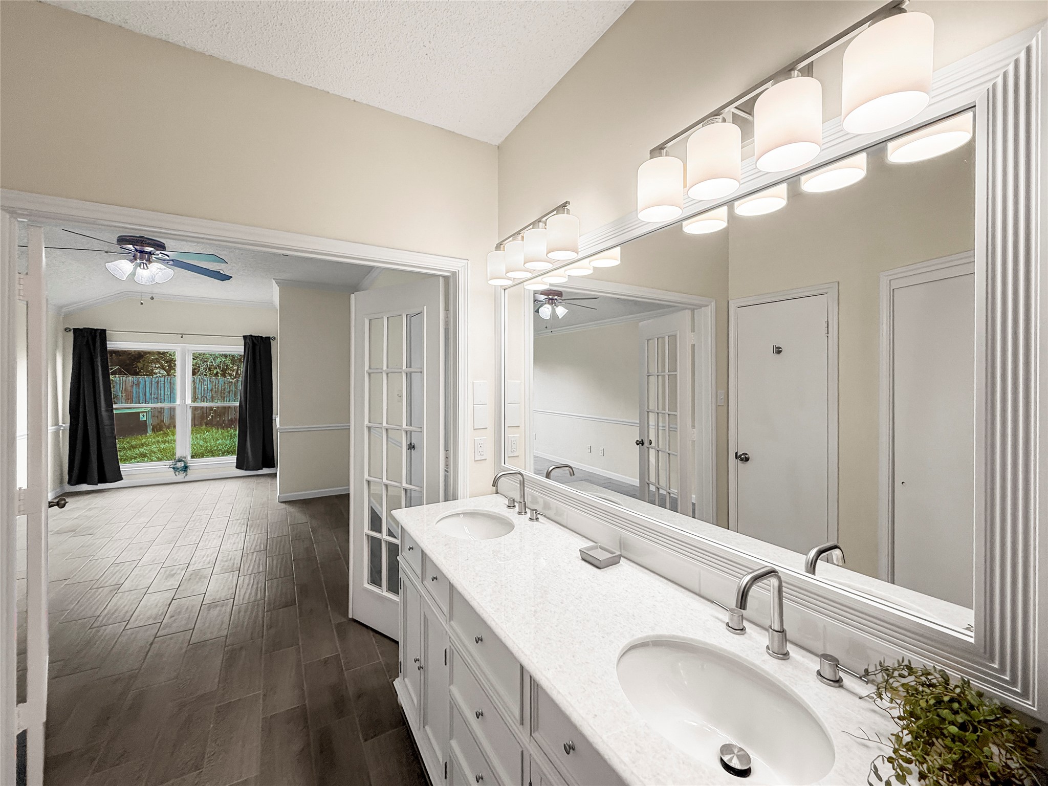 13635 Repa Lane Houston, TX 77014 - Photo 25 of 48 The primary bathroom features a spacious glass-enclosed shower, stylish tile flooring, and a double-sink vanity. French doors add elegance and natural light.