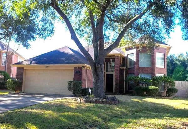 a view of a yard in front of a house with large tree